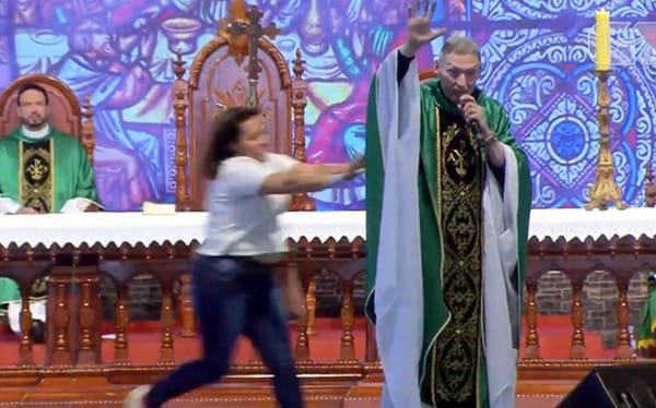 Woman pushes anti-gay priest off stage in front of 50,000 worshippers