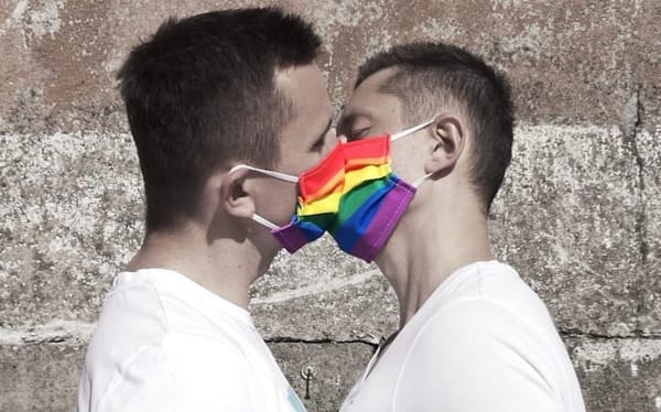 Gay couple protesting Poland’s “LGBT-free zones” with rainbow face masks