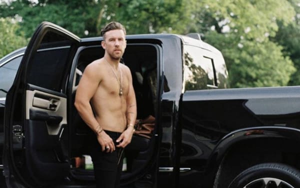 Country star T.J. Osborne kisses his boyfriend at the 2021 CMA awards