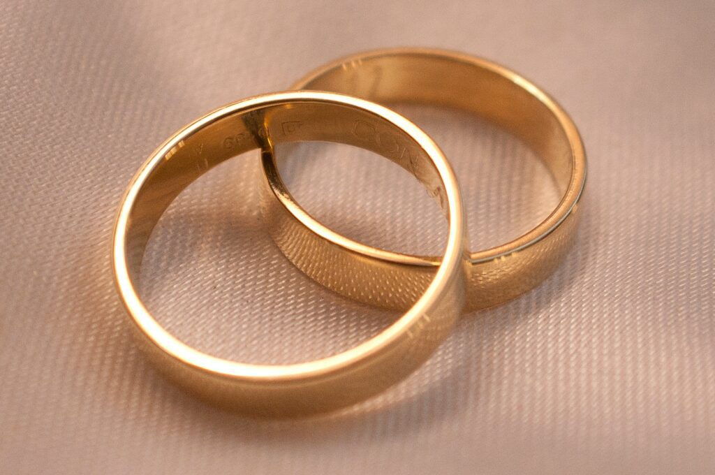 gold wedding rings on beige fabric background